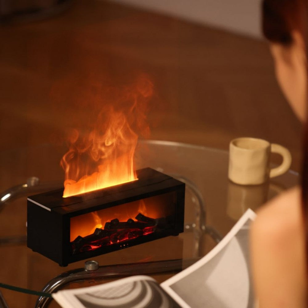 Fireplace aroma diffuser glowing on a glass side table beside a mug and an open magazine in the evening