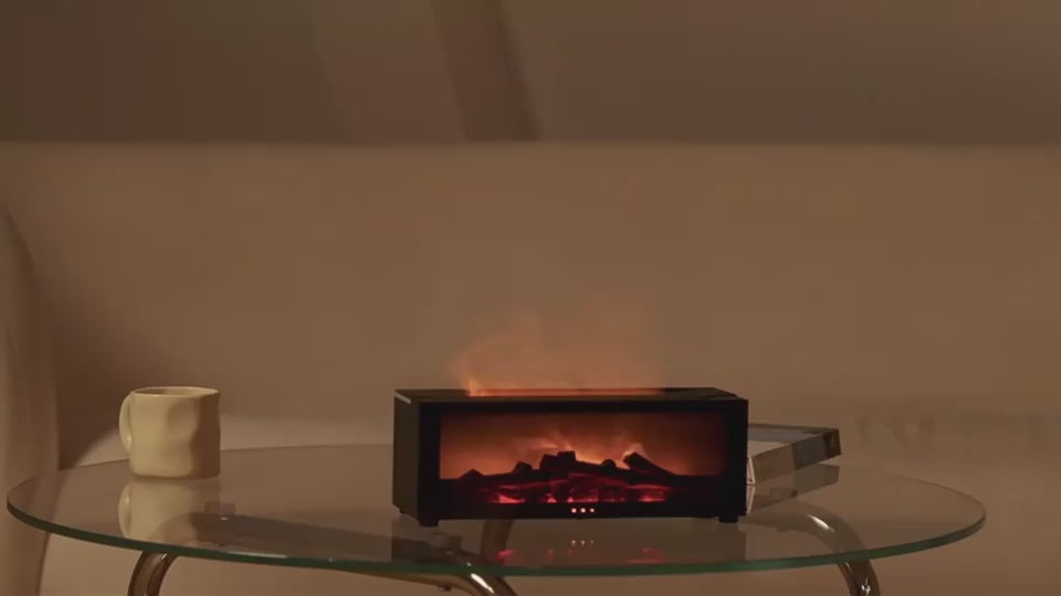 Fireplace aroma diffuser in matte black, flame effect and vapour, shown on a table and a sideboard