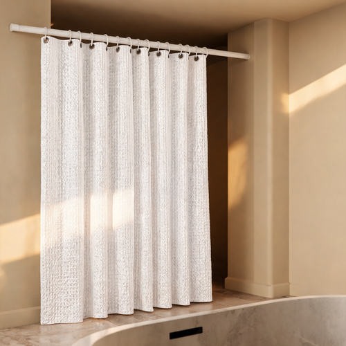 White waffle shower curtain hanging in a stone bathroom